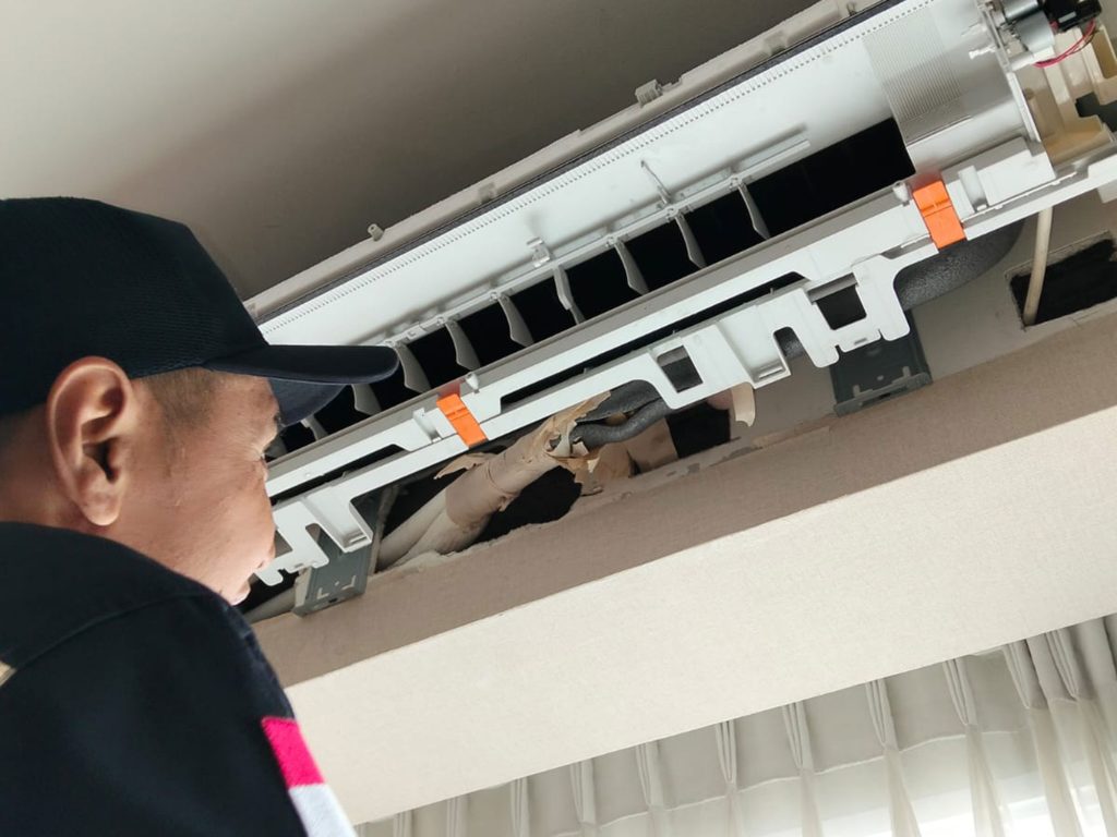 Teknisi AC buka cover lihat dalam